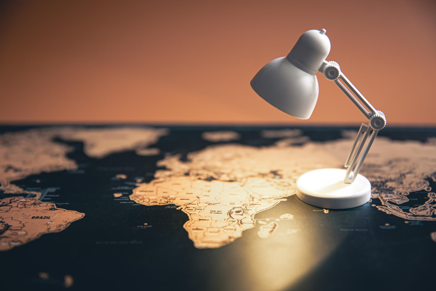 Small table lamp on world map copy space illuminating Africa